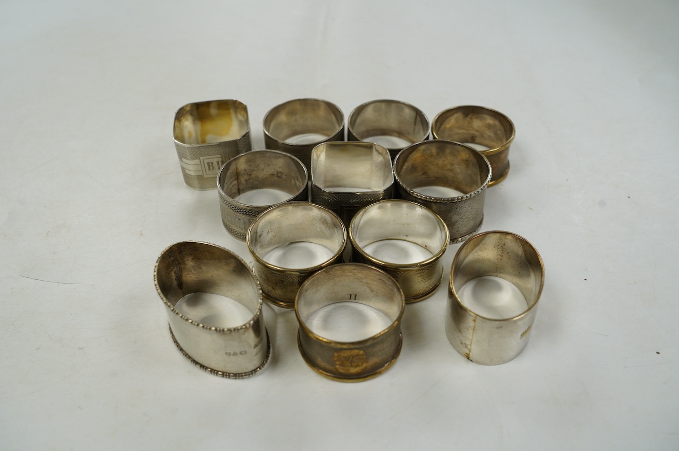 Eight assorted silver napkin rings, including a pair, Birmingham, 1937 and four plated napkin rings. Condition - fair